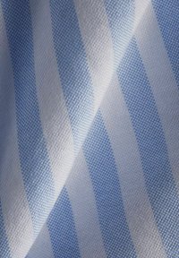 Sininen ja valkoinen raidallinen kangas, jossa on teksturoitu kudonta, jossa on vuorottelevat vaaleansiniset ja valkoiset raidat diagonaalisessa asennossa.