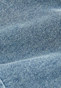 Tela de denim en azul claro con una textura sutil. Presenta un clásico tejido de sarga y un color uniforme en toda su extensión. Apta para ropa.