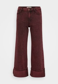 Jeans a gamba larga color bordeaux realizzati in denim con finitura texture, vita alta, passanti per cintura e orli risvoltati. Presentano uno stile classico a cinque tasche.