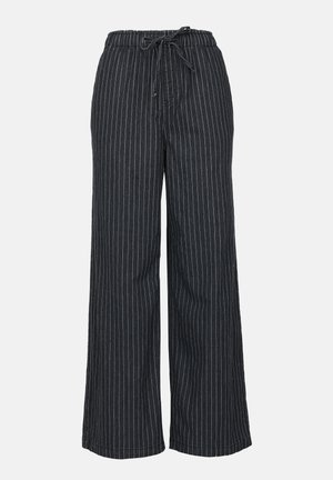 Sorte og hvide stribede viddebukser med elastisk talje og snor. Lavet af letvægtsstof med en glat tekstur.