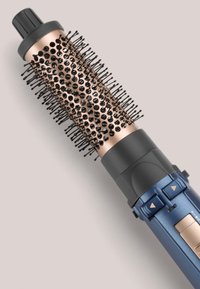 Brosse à coiffer avec un barillet en métal bronze et un manche en plastique noir. Présente des poils texturés et des boutons pour ajuster les réglages.