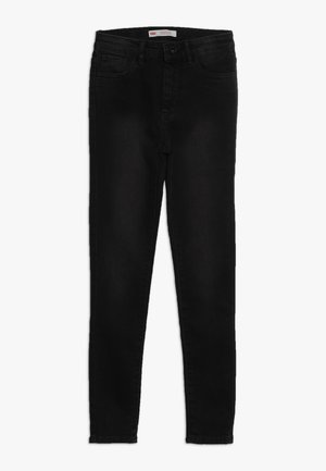 Jeans skinny neri con design a cinque tasche e chiusura con bottone, stesi su uno sfondo bianco.