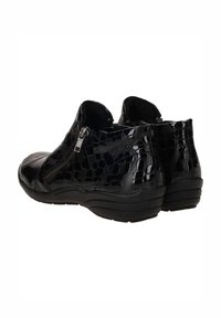 Chaussures noires à chevilles en matériau brillant, avec un motif reptilien, fermeture éclair sur le côté et semelle noire rembourrée.