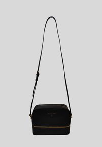 Borsa a tracolla in pelle nera con cerniera dorata, forma arrotondata, tracolla regolabile e logo impresso sulla parte anteriore.