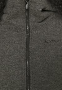 Giacca in fleece grigia con zip frontale, colletto alto e discreto logo del marchio. Tessuto testurizzato con un aspetto morbido.