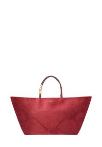 Sac fourre-tout en suède rouge avec un design triangulaire, poignées en cuir marron ornées de perles décoratives. Logo présent sur le devant.