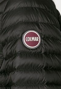 Svart puffjacka med quiltad design, med en rund Colmar-logotyp i bourgogne och grått på bröstet. Slät, glänsande textur.