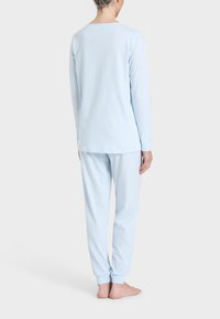Set di pigiama in cotone azzurro chiaro con maniche lunghe e pantaloni. I pantaloni hanno polsini elastici. Design semplice con una vestibilità comoda. Senza motivi o accenti.