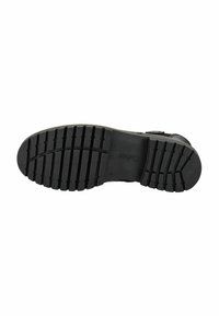 Suela de zapato de goma negra con patrón texturizado, que presenta ranuras horizontales y verticales para mayor tracción. Logo del fabricante presente.