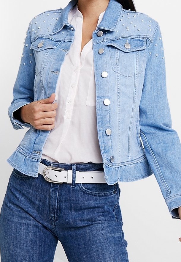 Ljust blå denimjacka med silvernitar på axlarna, klassisk krage och fickor fram. Har metallknappar och en figurnära design.