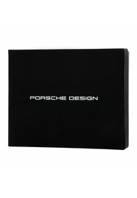 Boîte rectangulaire noire avec une texture mate lisse, portant l'inscription "Porsche Design" en argent. Design simple et moderne sans embellissements.