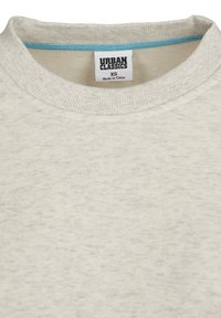 Lys beige sweatshirt med ribbet halslinning, som har en myk tekstur og en kontrastblå innerkrage. Merket viser "Urban Classics" og størrelse XS.