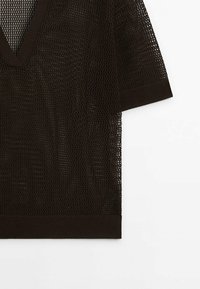 Haut court noir en maille, à manches courtes et col en V, présentant un motif en mesh et des poignets et une taille côtelés unis.