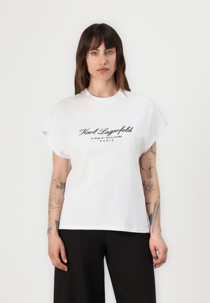 T-shirt en coton blanc à manches courtes et col rond. Affiche un imprimé noir : "Karl Lagerfeld 21 RUE ST. GUILLAUME PARIS" sur le devant.