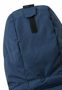 Dunkelblauer isolierter Winterhut mit einer weichen Textur. Verfügt über einen Klettverschluss und eine genähte Naht entlang der Kante für zusätzliche Haltbarkeit.