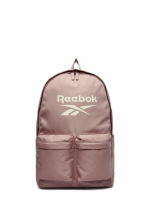 Jasnofioletowy plecak Reebok z dwoma przednimi kieszeniami na suwak i górnym uchwytem, z logo Reebok w kolorze białym na przednim panelu.
