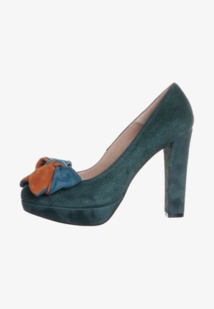 Teal ruskinds højhælede pumper med rund tå og stor flerfarvet sløjfe (blå og orange) foran. Tekstureret overflade, platformdesign.