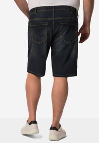 Pantalones cortos de mezclilla azul oscuro con corte recto, cinco bolsillos y costuras de contraste. Presentan un dobladillo vuelto y una cinturilla resistente.