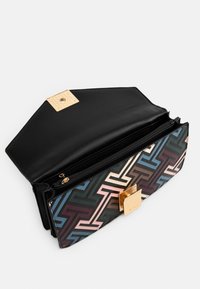 Texturerad svart läderväska med ett flerfärgat geometriskt mönster och ett guld fyrkantigt lås. Fickan med dragkedja inuti är synlig.