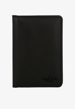 Zwarte leren paspoorthouder met stiksels langs de randen en een geperst "Gusti Leder studio" logo rechtsonder.