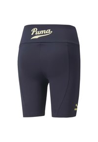 Marina atletiska shorts med en gyllene Puma-logotyp på midjan. Tillverkad av stretchigt material, med en åtsittande design och slät textur.