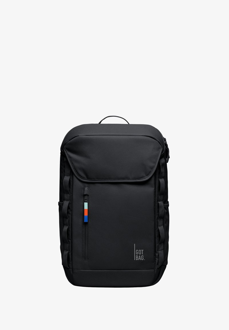 Musta reppu, jossa on säädettävät hihnat, teksturoitu kangas, etuosan vetoketjullinen tasku ja pieni värillinen lappu, jossa on sinisiä, punaisia ja vaaleansinisiä raitoja.