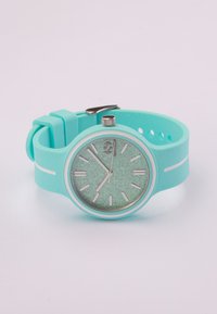 Reloj de pulsera de silicona verde menta con detalles en plata; la esfera redonda presenta una dial verde brillante y marcadores de horas blancos, asegurado con una hebilla.