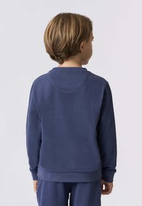 Sweatshirt blu navy con scollo rotondo e maniche lunghe. Tessuto liscio, dettagli di cucitura minimi sulla schiena e sui polsini.