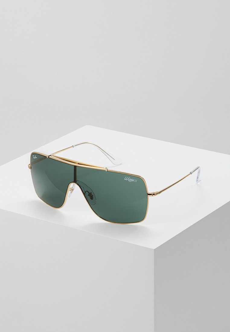 Occhiali da sole con montatura dorata e lenti verde scuro. Forma rettangolare con una grande area delle lenti e steli sottili. Logo sulla lente sinistra.