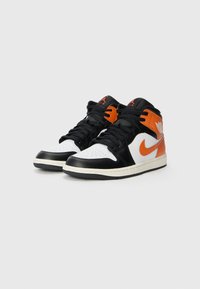Black, white, and orange high-top sneakers with a leather upper, perforated toe, black laces, and a white midsole. Features Nike logo accents.
