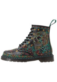 Botín de cuero negro hasta el tobillo con diseños florales y de calaveras coloridos, con cordones negros, suela texturizada y una lengüeta en la parte posterior.