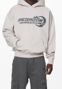 Pegador Jersey con capucha - sand