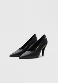 Sorte læder højhælede pumps med spids tå og en subtil udskæringsdesign. Har en slank hæl og minimalistisk accentdetalje.