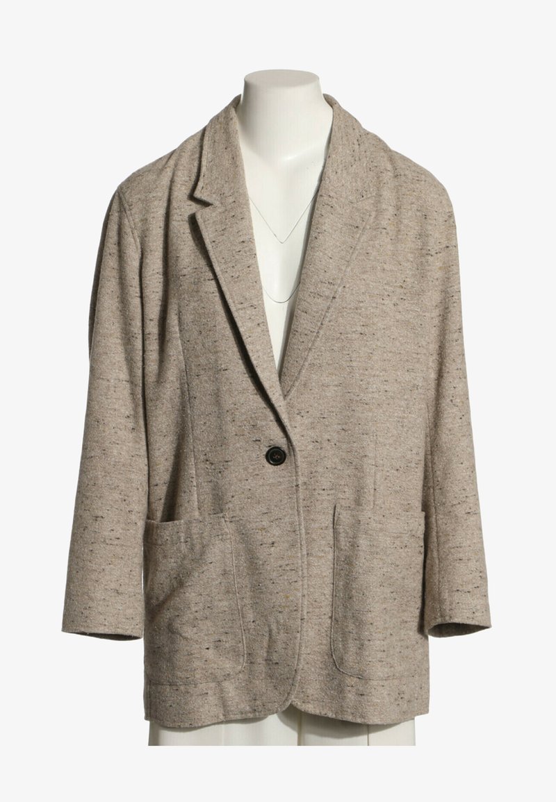 Blazer beige tacheté à bouton unique avec revers crantés et deux poches plaquées devant sur un buste de mannequin blanc.