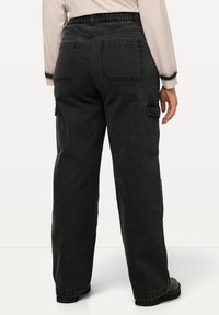 Pantalones cargo negros con un corte relajado, que cuentan con un diseño de bolsillo trasero y una cintura elástica, fabricados en tejido de mezclilla.