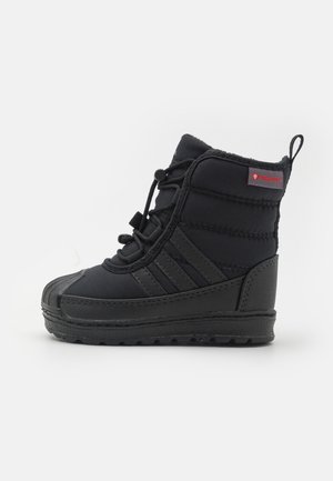 Botte d'hiver isolée noire avec semelle en caoutchouc, lacets à l'avant et languette au talon, conçue pour le froid et la protection contre la neige.