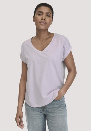 Lichtpaarse v-hals t-shirt met opgerolde korte mouwen, gemaakt van zachte stof. Gecombineerd met lichtblauwe jeans, met een losse pasvorm.