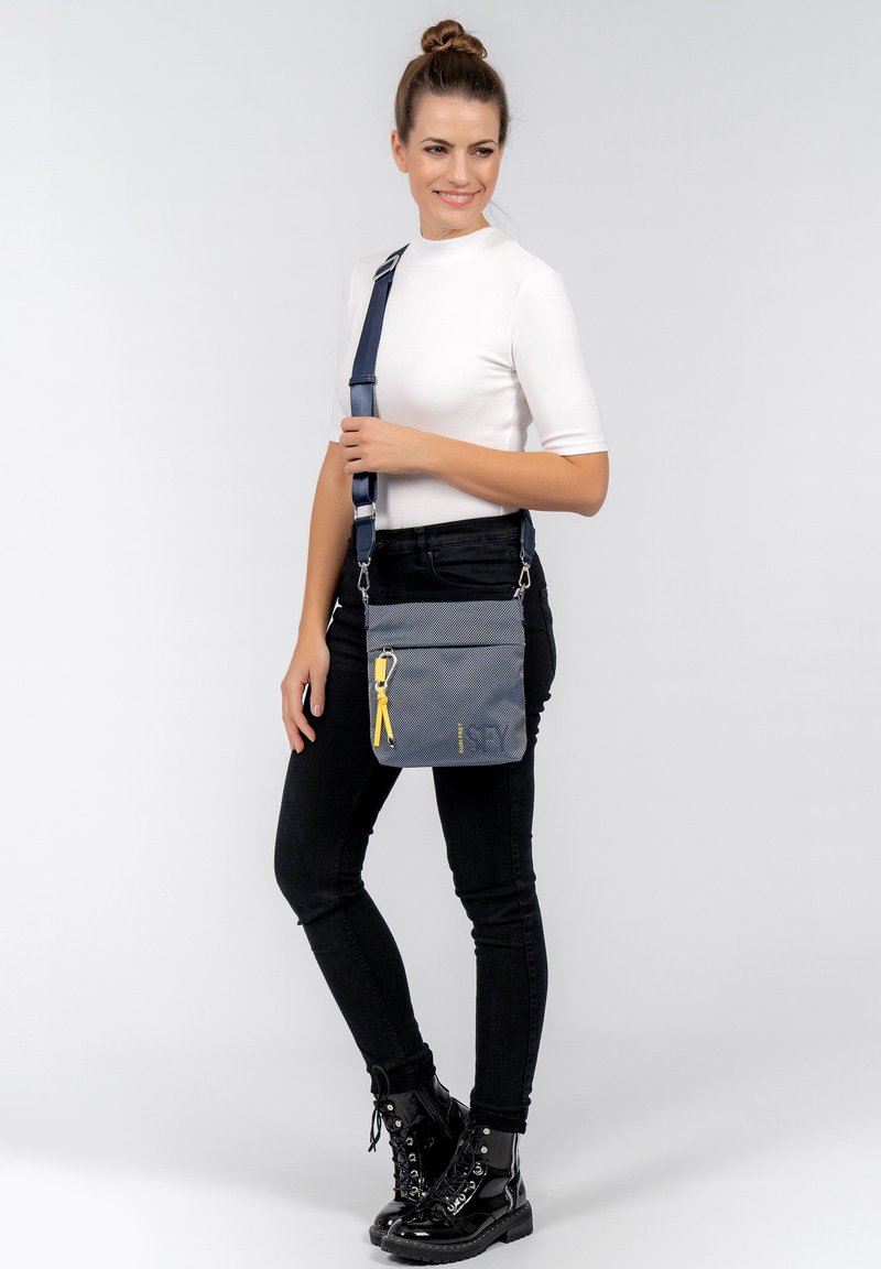 Borsa a tracolla grigia con patta, zip gialla e logo. Presenta una tracolla staccabile e una texture a griglia sottile.