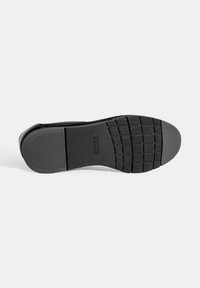 Zwarte schoenzool van rubber met een gestructureerd oppervlak, voorzien van horizontale en verticale groeven voor grip. Het Flex & Go-merkteken is zichtbaar.