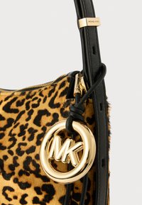 Τσάντα χειρός με σχέδιο λεοπάρντα σε υφασμάτινη υφή με μαύρες δερμάτινες λεπτομέρειες, διαθέτει χρυσό κυκλικό λογότυπο "MK" και κλείσιμο με φερμουάρ.
