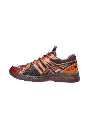 Zapatillas deportivas en materiales rojos, naranjas y verde oscuro; parte superior texturizada con malla; diseño estratificado distintivo; suela flexible con patrón de agarre.