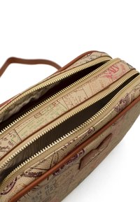 Beżowa torba z płótna z teksturowanym nadrukiem mapy; zawiera dwa złote suwaki, brązowe skórzane akcenty oraz liczne wnętrza przegród.