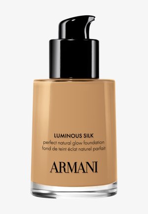 Flacon en verre de fond de teint Armani Luminous Silk avec distributeur noir, liquide beige et nom ainsi que description du produit imprimés en noir.