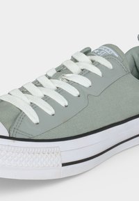 Ανοιχτό γκρι sneaker χαμηλού ύψους με λευκά κορδόνια, ελαστική σόλα με μαύρη ρίγα και λογότυπο Converse Star στη γλώσσα.