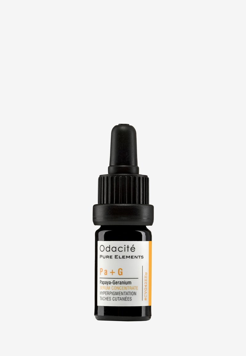Svart glassdroppflaske med svart lokk, med en hvit og oransje etikett som sier "Papaya-Geranium Serum Konsentrat."