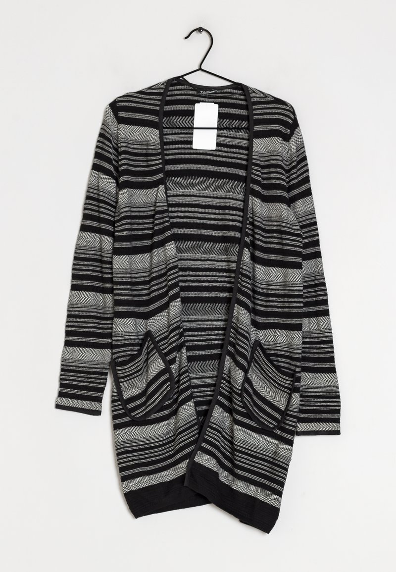 Gilet noir et gris à rayures, avec une ouverture à l'avant, des manches longues et deux poches avant. Fabriqué en tissu texturé ; suspendu à un crochet noir.