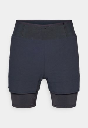 Męskie spodenki sportowe w ciemnoniebieskim kolorze, z dopasowaną wewnętrzną warstwą i luźniejszą zewnętrzną warstwą, zaprojektowane z myślą o komforcie i elastyczności.