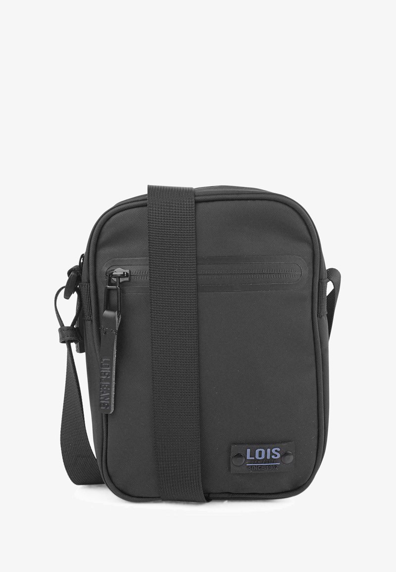 Bolso cruzado de nylon negro con correa ajustable, bolsillo delantero con cremallera y detalle sutil del logo. Forma rectangular con textura suave.