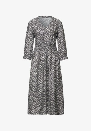 Bloemenprint jurk met een V-hals, lange mouwen, gerimpelde taille en een vloeiende rok in marineblauw en crèmekleur met bladerenpatronen.