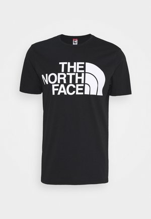 Sort t-shirt med korte ærmer med stor hvid "THE NORTH FACE" tekst og halvkuglelogo trykt på frontens midte.